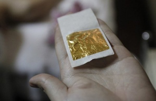 Một lá vàng trước khi được sử dụng để đắp lên mặt cho khách hàng tại thẩm mỹ viện Việt Mỹ hôm 13/2 (Ảnh: Reuters)
